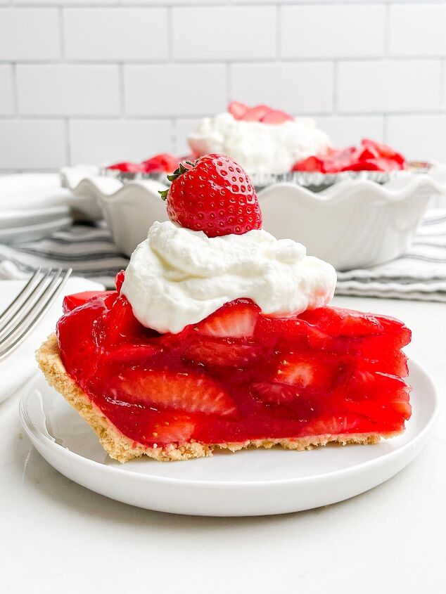 no bake strawberry pie with jello, side view of piece of strawberry pie topped with whipped cream and a strawberry