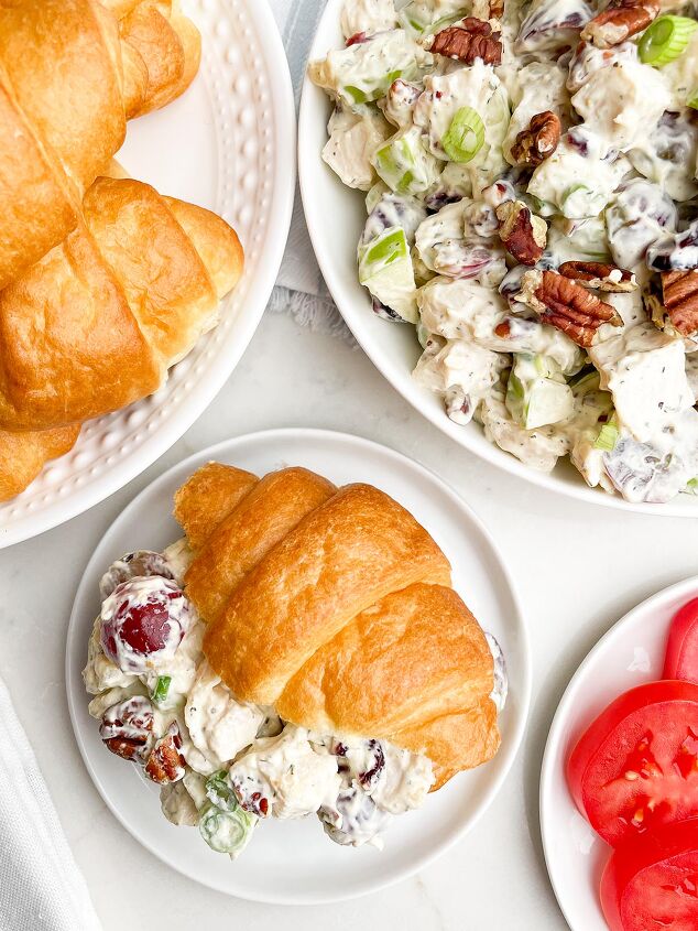cranberry pecan chicken salad, cranberry pecan chicken salad on a croissant with bowl of salad and plate of croissants in background