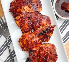 air fryer bbq chicken thighs boneless or bone in, air fryer bbq chicken thighs on a white platter next to bowl of bbq sauce