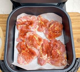 air fryer bbq chicken thighs boneless or bone in, uncooked boneless skinless chicken thighs on parchment in air fryer