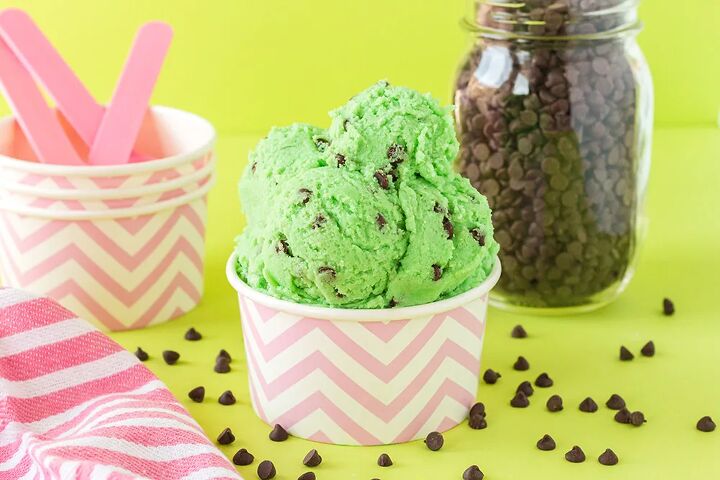 mint chip edible cookie dough, Scoops of mint chip cookie dough in a pink striped cup with chips on the table