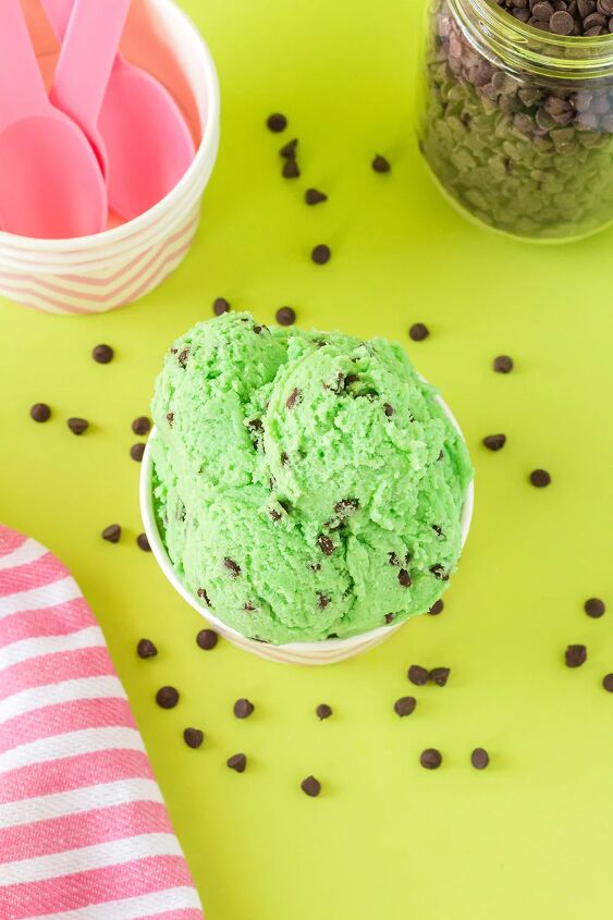 mint chip edible cookie dough, Overhead shot of mint chip cookie dough on a green table surrounded by mini chips and pink spoons