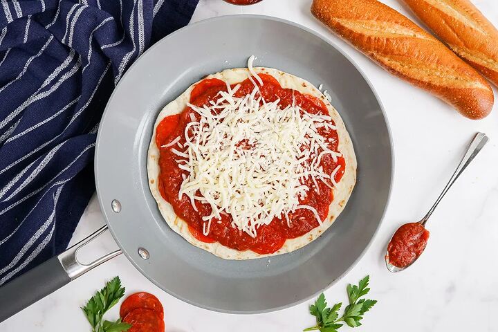 skillet pepperoni pizza quesadillas recipe, Shredded mozzarella on top of a sauced tortilla in a skillet
