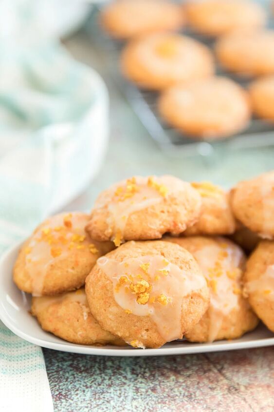 unique carrot cookies with orange juice glaze, Plate of carrot cookies with more cooling on a rack in the background