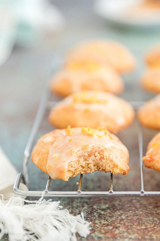 unique carrot cookies with orange juice glaze, Orange cookie with a bite taken out of it on a rack