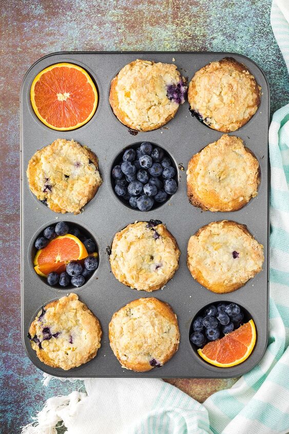 blueberry orange muffins with crunchy oat topping, Muffin tin with muffins oranges and blueberries in it