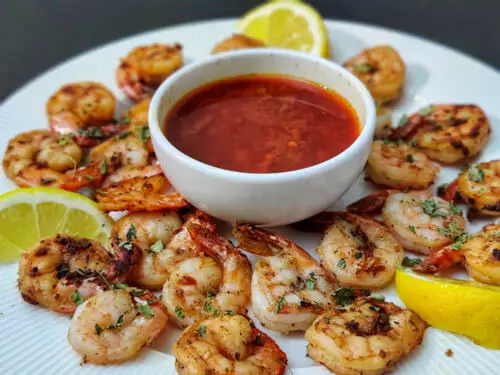 crispy pan fried shrimp easy recipe, pan fried shrimp on white plate with blove sauce on white bowl at the center
