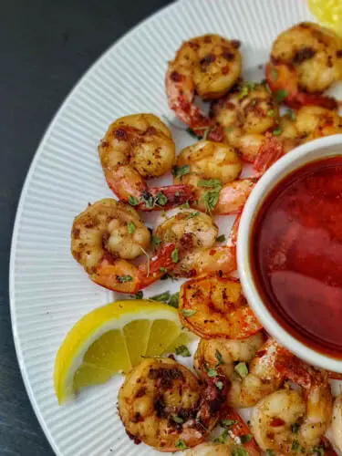 crispy pan fried shrimp easy recipe, pan fried shrimp on white plate served with blove sauce on white bowl