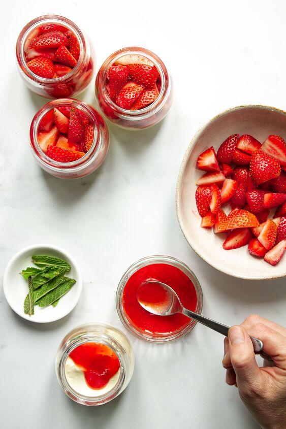 strawberries and cream, Dessert bowls being assembled by putting an equal amount of whipped cream in each then adding some coulis and fresh strawberries