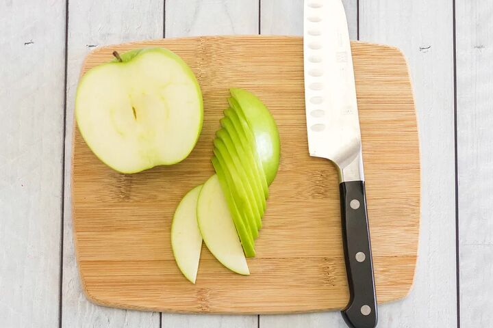 crunchy apple nachos with sweet and salty toppings, Slicing green apples on a cutting board