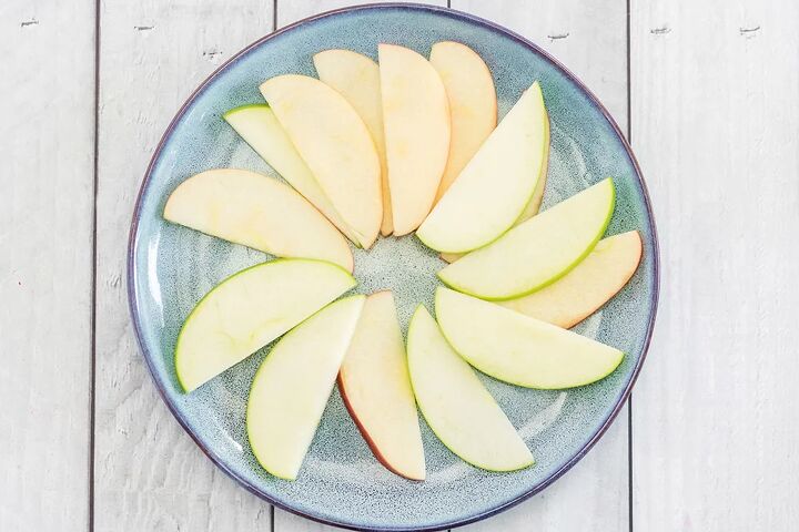 crunchy apple nachos with sweet and salty toppings, Apple slices arranged on a blue plate