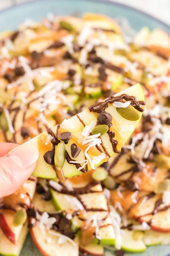 crunchy apple nachos with sweet and salty toppings, Apples topped with nuts caramel and chocolate for apple nachos