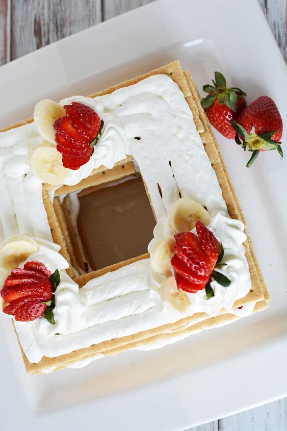 banana split icebox cake no bake recipe, Overhead shot of ice box cake topped with whipped cream and strawberries
