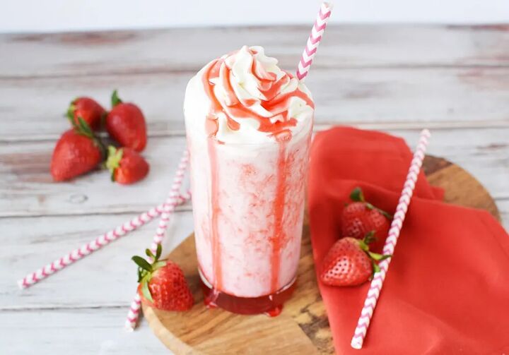 delicious copycat strawberry frappuccino recipe, Glass of strawberry blended drink with red syrup on top of the whipped cream
