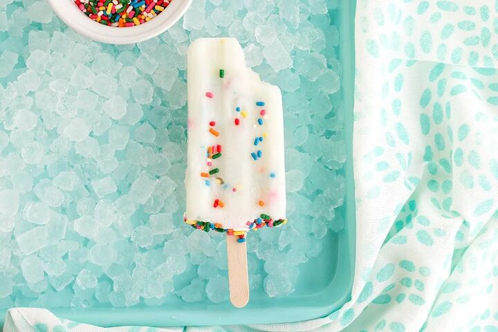happy funfetti cake batter popsicles, Bite taken out of a cake mix popsicle on ice
