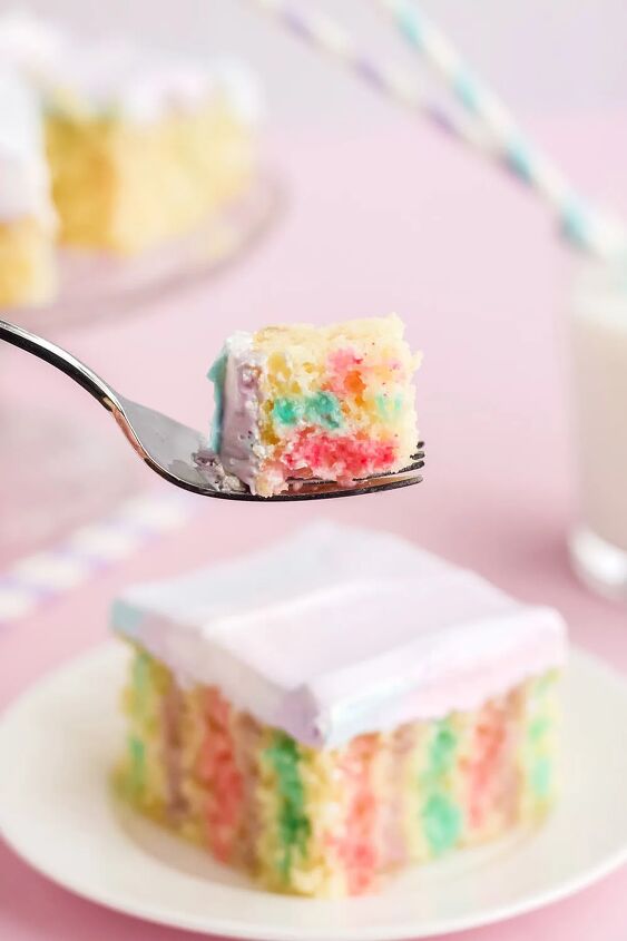 rainbow unicorn poke cake recipe, Fork with cake on it in front of a poke cake on a plate