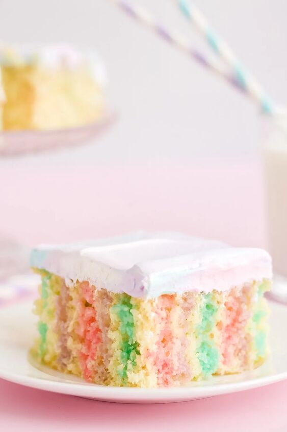 rainbow unicorn poke cake recipe, Unicorn poke cake on a plate with a pink background