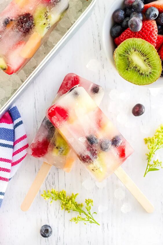 rainbow fruit popsicles, Fruit pops surrounded by fruits on a white table