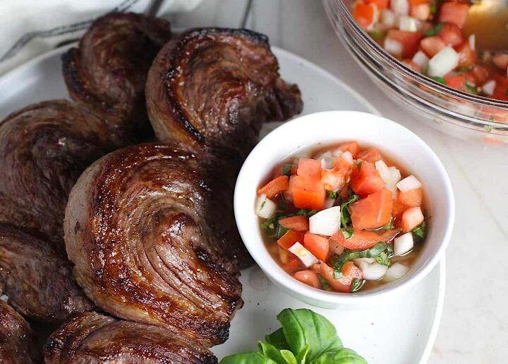 Tomato and Onion Salad in a bowl next to Picanha skewered steaks