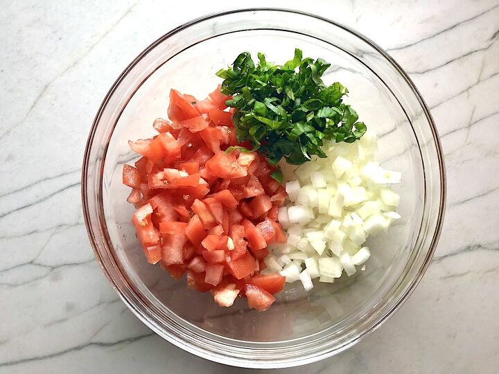 Diced tomato diced onion basil in sections in a clear bowl for Tomato and onion salad in clear bowl on counter with towel