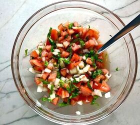 Tomato and onion salad in clear bowl on counter It has diced tomato diced onion basil and vinegar
