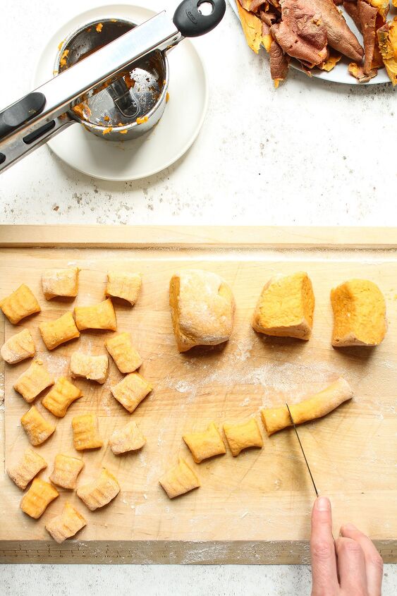 sweet potato gnocchi with brown butter and sage, Preparing the gnocchi for cooking by chopping the dough into one inch pieces on a wooden chopping boart