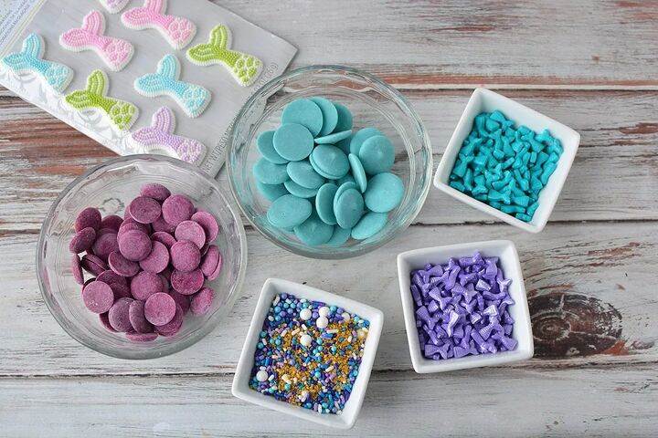 mermaid hot chocolate bombs, Candy fins purple and blue melting chocolate discs and sprinkles in bowls on a table