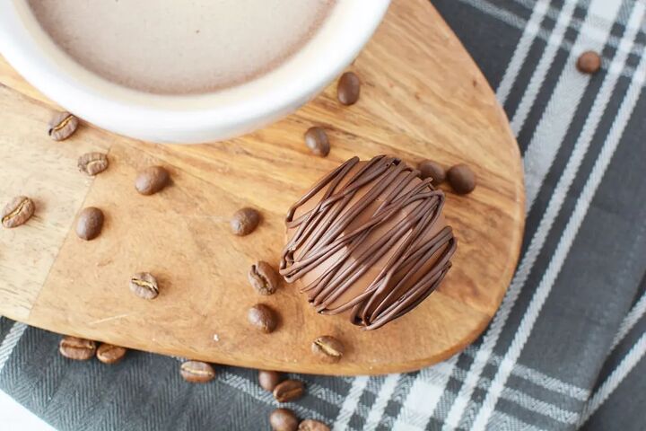 how to make mocha coffee bombs, Mocha coffee bomb sitting next to a mug of coffee on a board with coffee beans