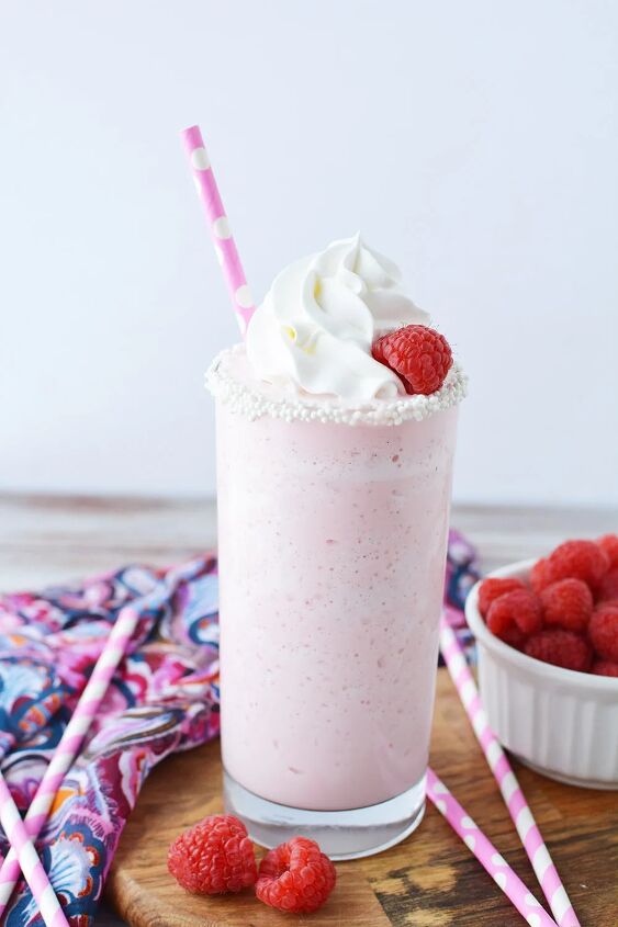 copycat raspberry cotton candy frappuccino recipe, Glass of cotton candy frappuccino topped with whipped cream and raspberry and a pink straw