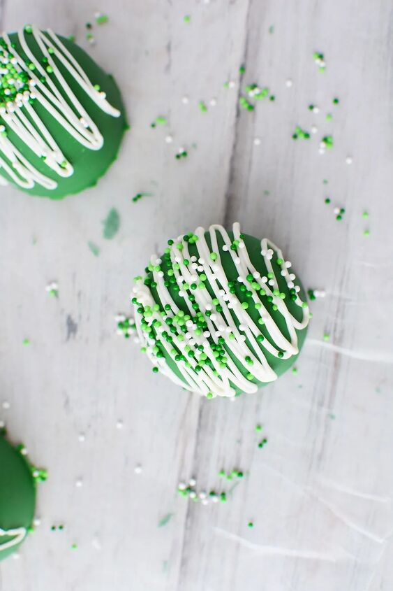 glittery green hot chocolate bombs recipe, Topping a green hot chocolate bomb with St Patrick s Day sprinkles