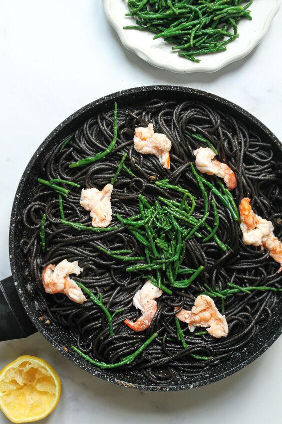 black squid ink pasta, The cooked squid ink pasta served with cooked prawns samphire and lemon juice with a plate of samphire and a squeezed half lemon
