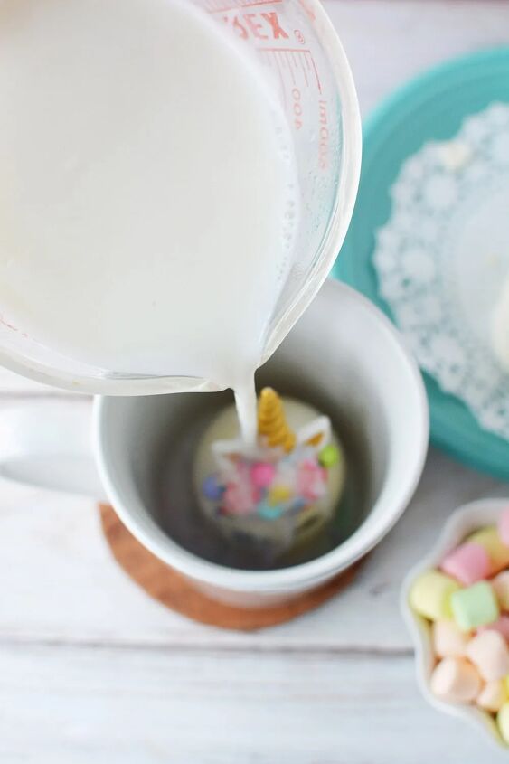 adorable unicorn hot chocolate bombs, Pouring hot milk onto unicorn hot chocolate bomb in mug