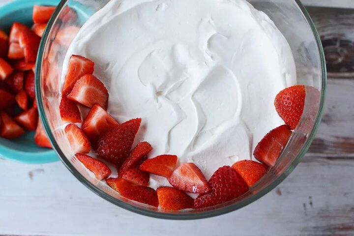 irresistible strawberry cheesecake trifle recipe, Fresh strawberries on top of whipped cream in a trifle bowl