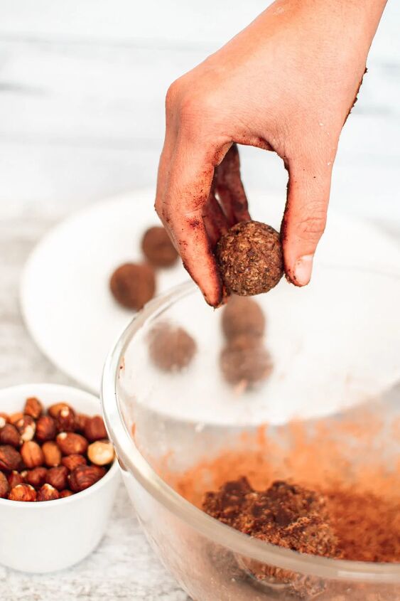 homemade chocolate coconut date balls, Rolling the date mixture into energy balls