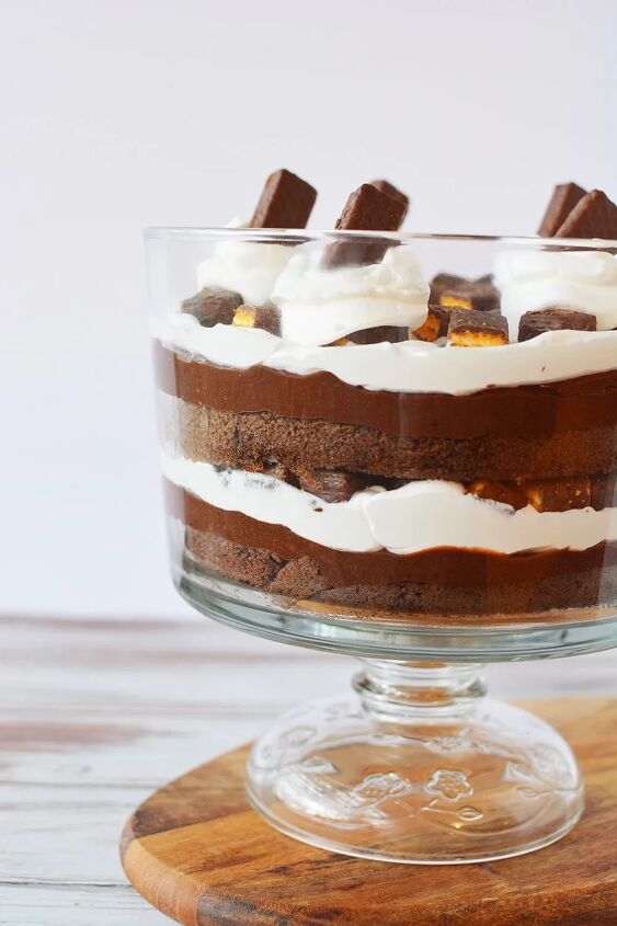 chocolaty chocolate trifle recipe, Chocolate trifle with layers of pudding whipped cream and cake in a bowl sitting on top of a cutting board