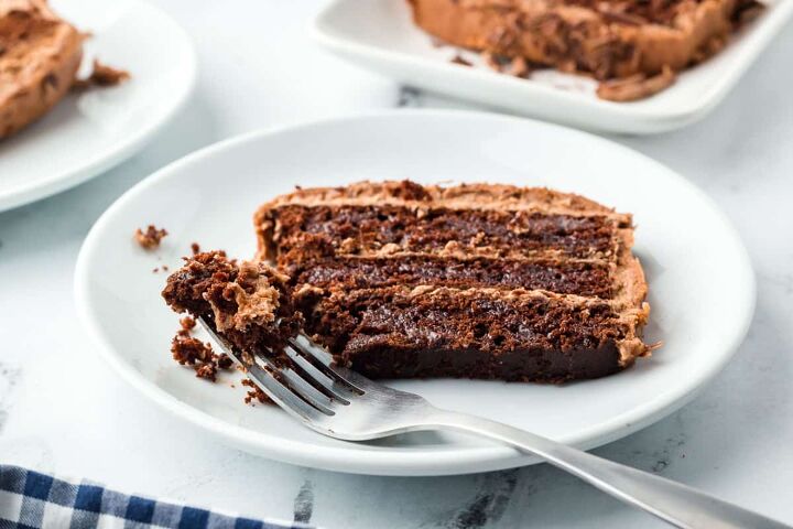 chocolate fudge cake, A slice of chocolate cake on a white plate with a fork