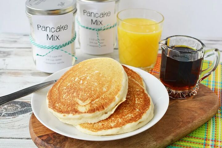 homemade pancake mix recipe to stock your pantry, Pancakes on a plate with jars of homemade pancake mix orange juice and syrup