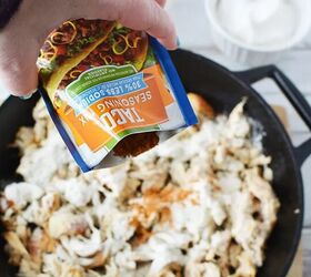 easy and flavorful chicken ranch tacos, Pouring taco seasoning onto shredded chicken in a skillet