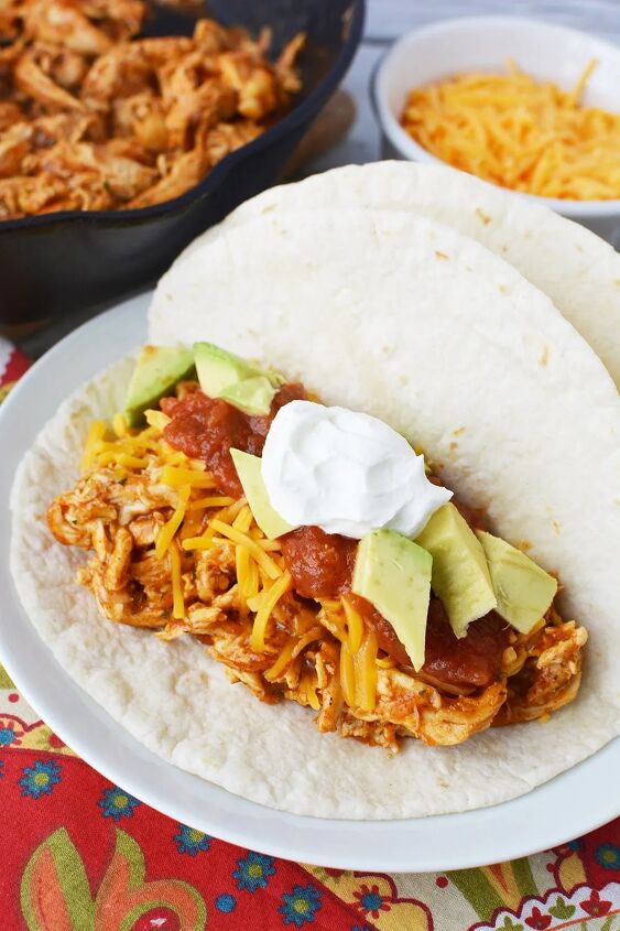 easy and flavorful chicken ranch tacos, A plate of shredded chicken tacos with ranch and toppings