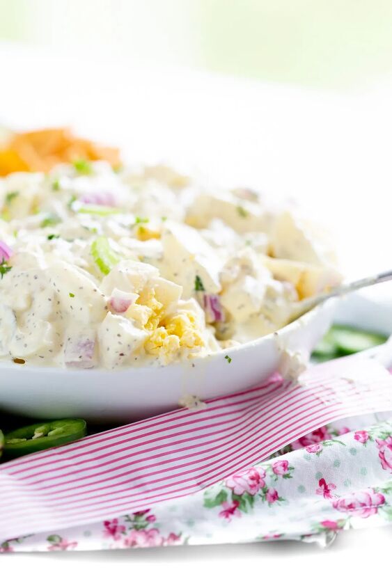 how to make traditional potato salad recipe this weekend, up close view of potato salad being served for summer chopped celery chopped red onion parsley chopped boiled eggs