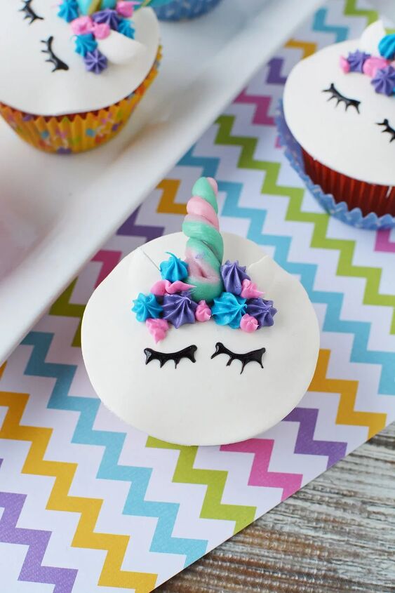 adorable unicorn cupcakes with horns and eyes, A unicorn cupcake with ears a candy horn a frosting mane and eyes
