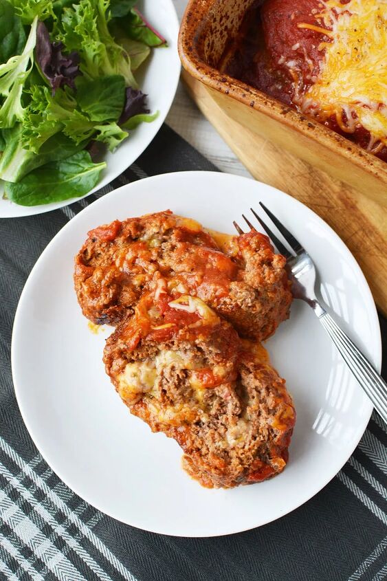 easy cheese stuffed meatloaf comfort food recipe, Slices of cheese sliced meatloaf on a plate with fork and next to a salad