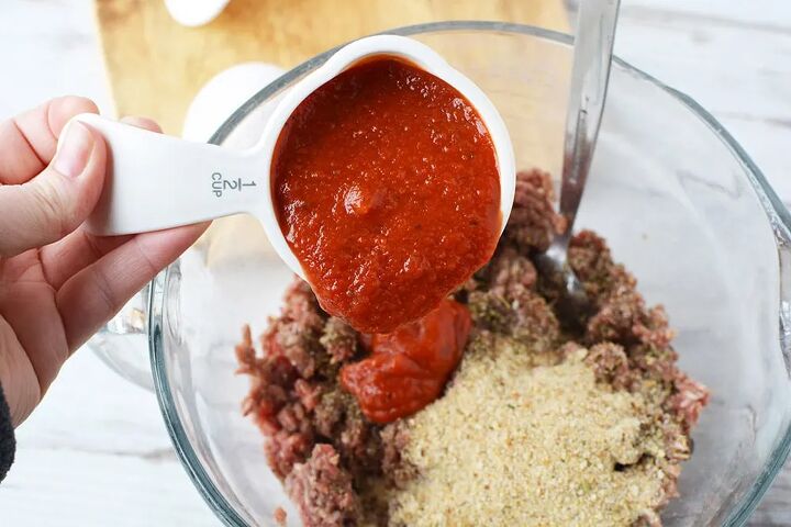 easy cheese stuffed meatloaf comfort food recipe, Adding 1 2 cup of pasta sauce into ground beef mixture