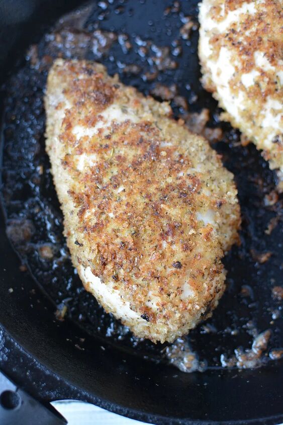 easy parmesan crusted chicken recipe, Chicken coated with bread crumbs frying in pan