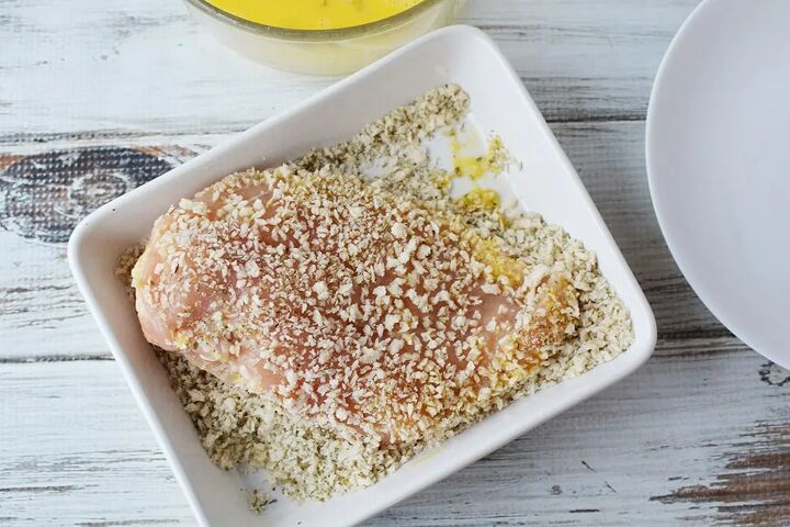 easy parmesan crusted chicken recipe, Chicken coated with bread crumbs in a dish