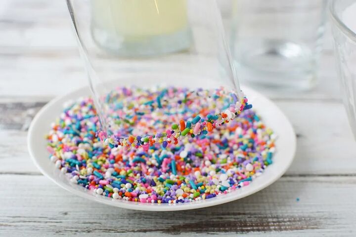 rainbow unicorn slush icy lemonade, Dipping a glass into rainbow sprinkles on a plate