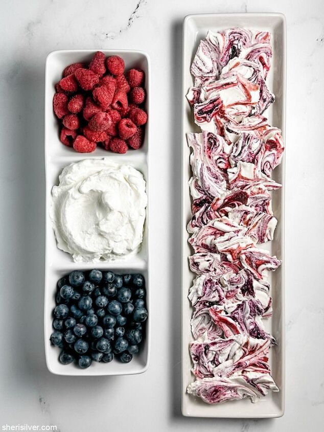 make this easy mixed berry meringue bark recipe for memorial day, berries and whipped cream in a divided ceramic tray next to a tray of berry meringue bark