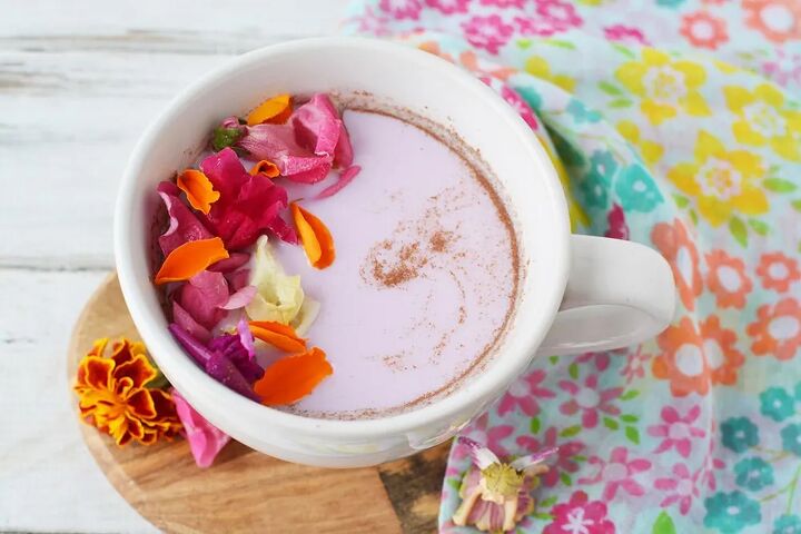 warm and cozy fairy flower moon milk, Mug of pink moon milk with edible flowers on top