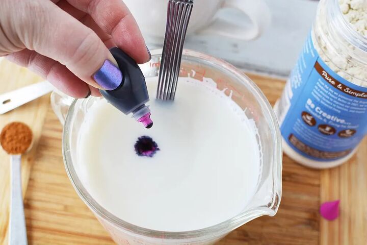 warm and cozy fairy flower moon milk, Dropping purple food coloring into a glass of milk