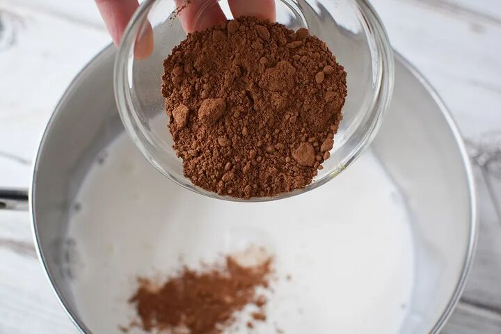 copycat salted caramel mocha drink recipe, Pouring cocoa into milk in saucepan
